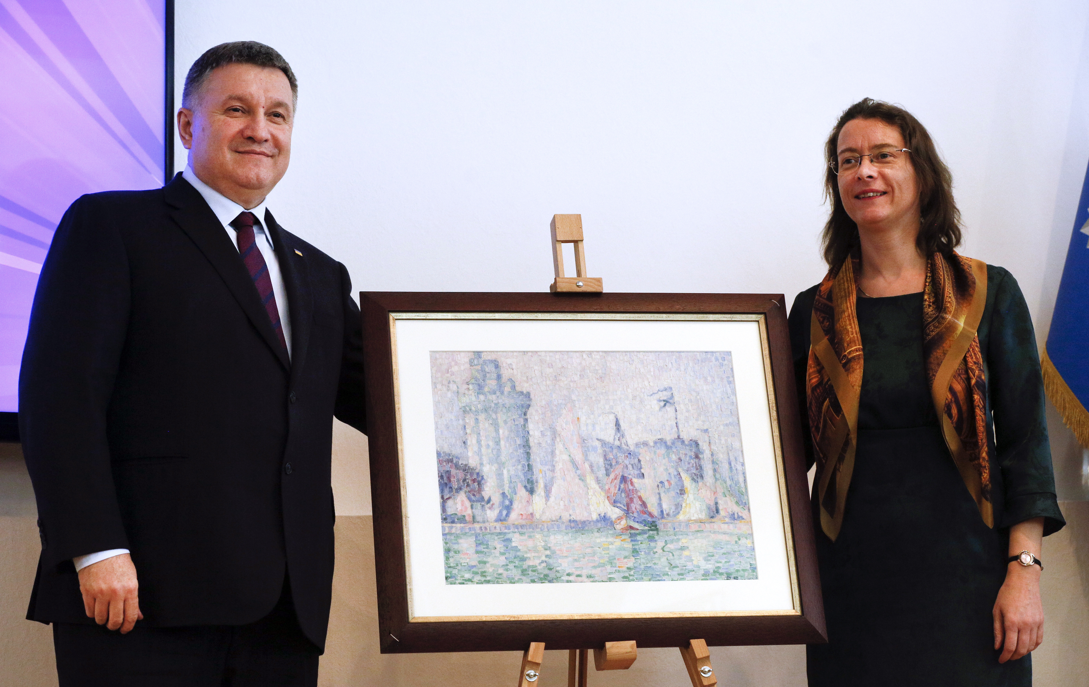 Ukrainian Interior Minister Arsen Avakov, left, and French Ambassador to Ukraine Isabelle Dumont pose for a photo with the 1915 painting. Image: Efrem Lukatsky via The Public's Radio