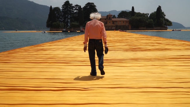 Christo tar en promenad på hans senaste offentliga projekt, The Floating Piers Lake Iseo, Italy 2014-16
