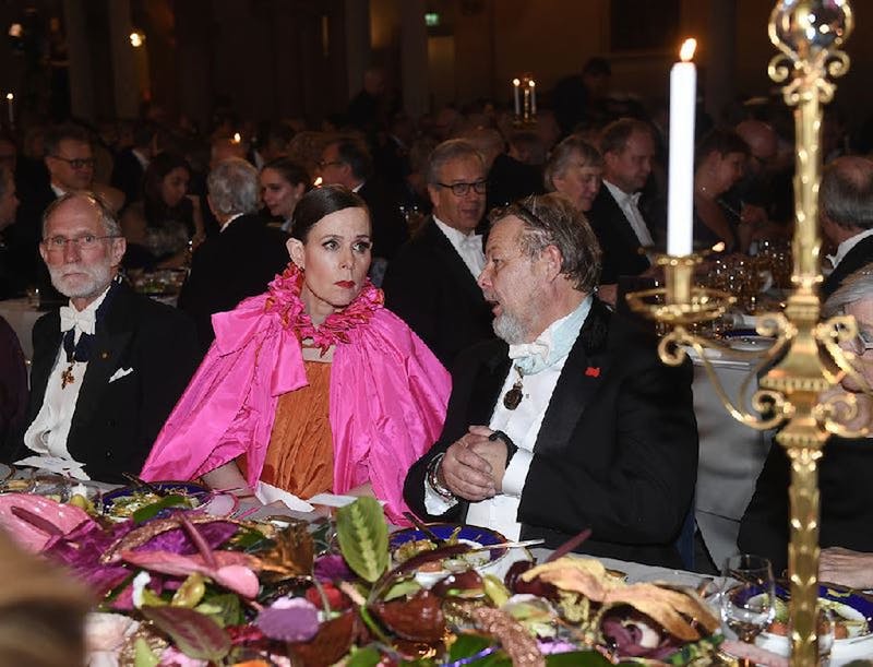 Sara Danius, ledamot i Nobelstiftelsens styrelse, i den hänförande klänningen i orange och Schiaparellirosa med bordsherren finansmannen Peter ”Poker” Wallenberg