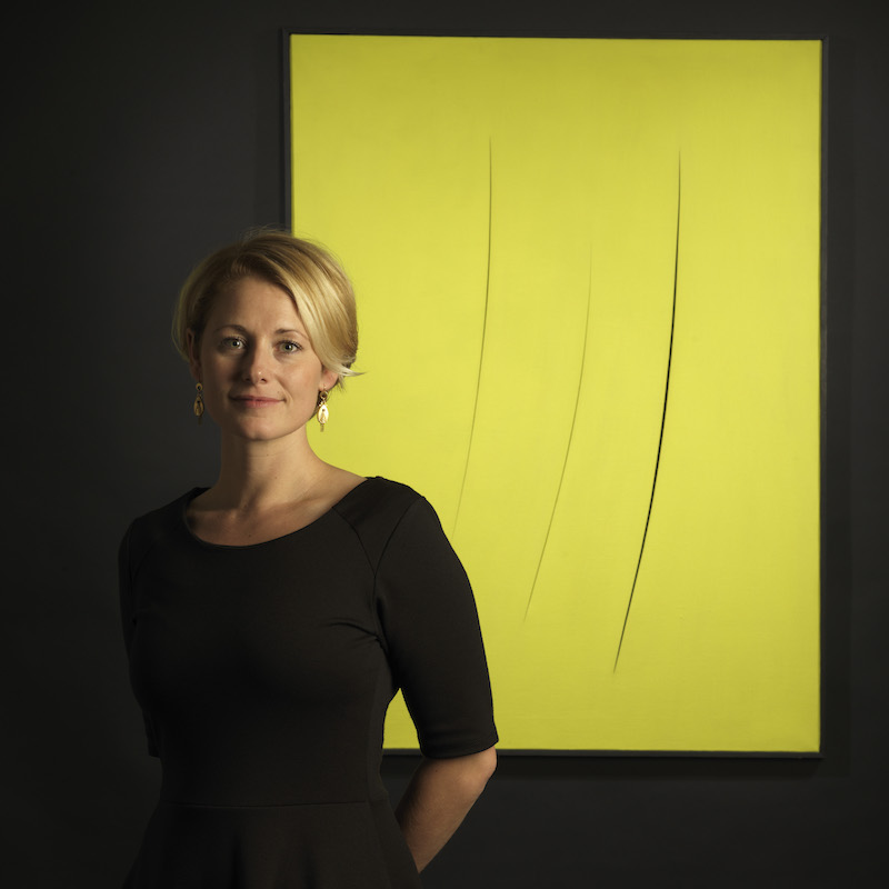 Stockholms Auktionsverks Sofie Bexhed framför en målning av Lucio Fontana, tillika ett av de högsta klubbslagen hos Stockholms Auktionsverk förra året
