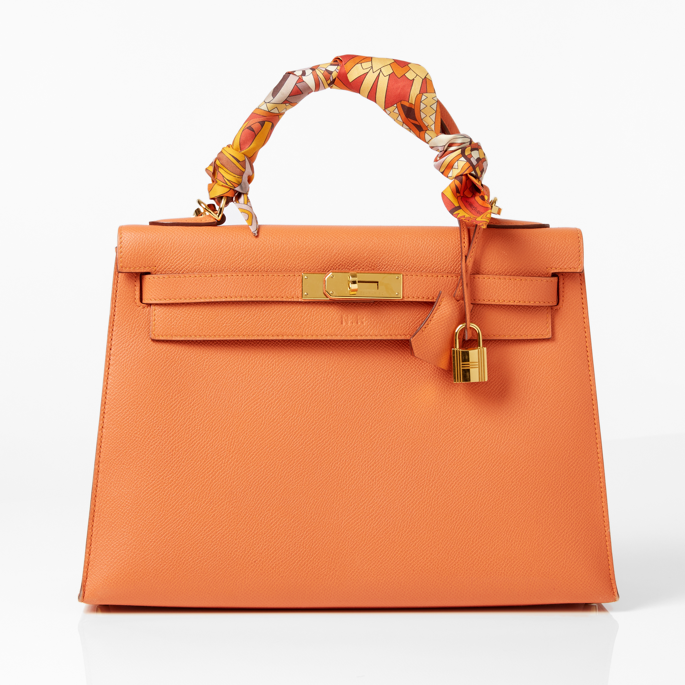 HERMÈS, handväska Kelly 32 cm i orange Epsom kalvskinn rigid med guldpläterat spänne och lås, handtag med tvinnad twilly i foulardsiden. Bild: Stockholms Auktionsverk