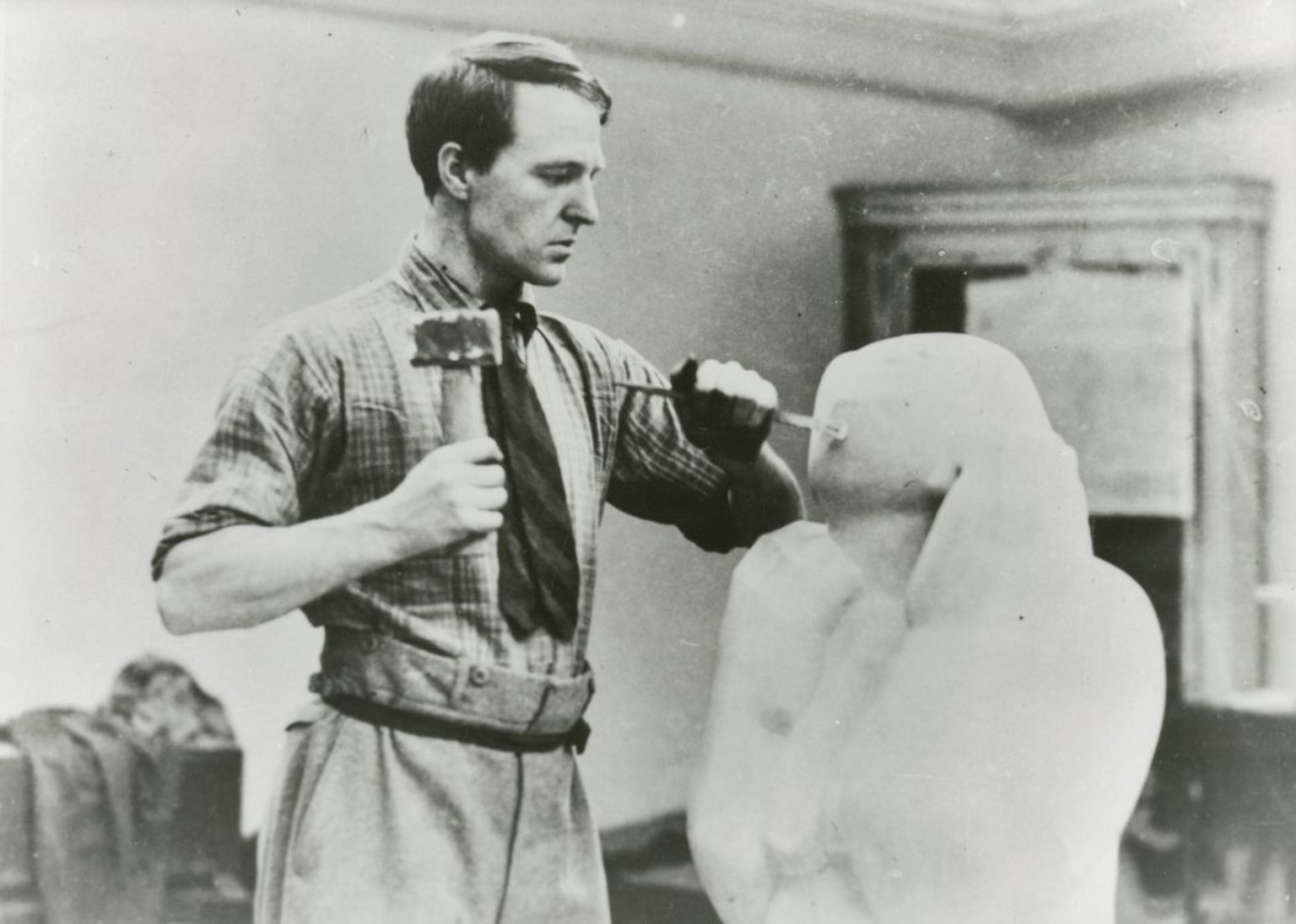 Photographie de Henry Moore en train de tailler la pierre dans les studios Grove, au numéro 3, à Hammersmith, 1927 © The Henry Moore Foundation