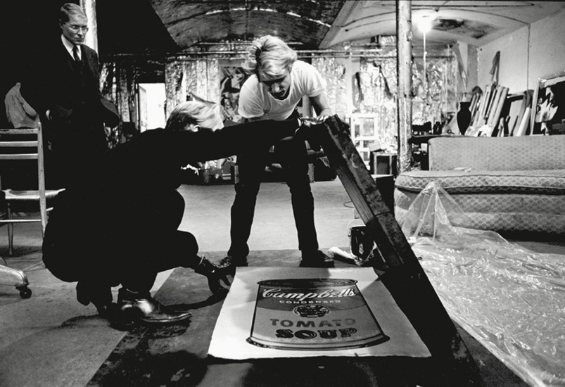 Working with Gerard Malanga on silk-screening 'Campbell's Soup Can' paintings at The Factory in 1965 Image via Phaidon