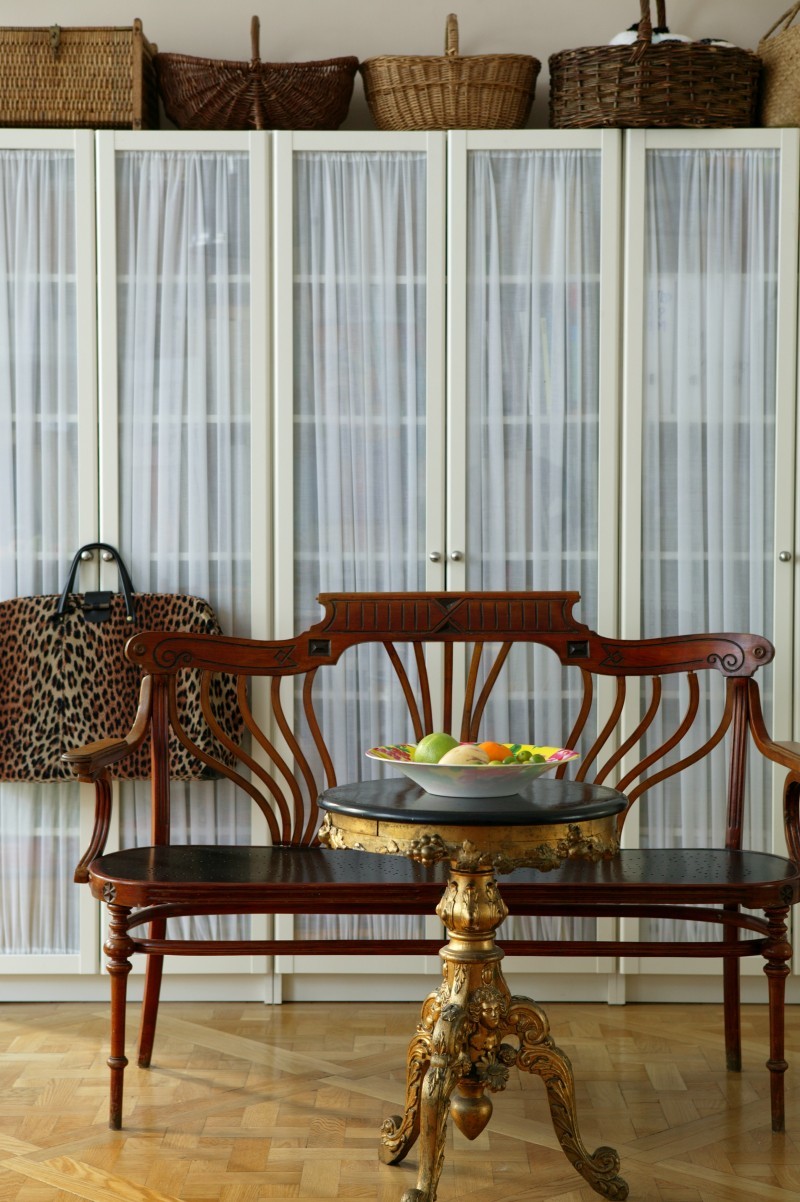 Un canapé et un plateau de style Art Nouveau orné d'ornements baroques devant l'étagère Billy d'IKEA