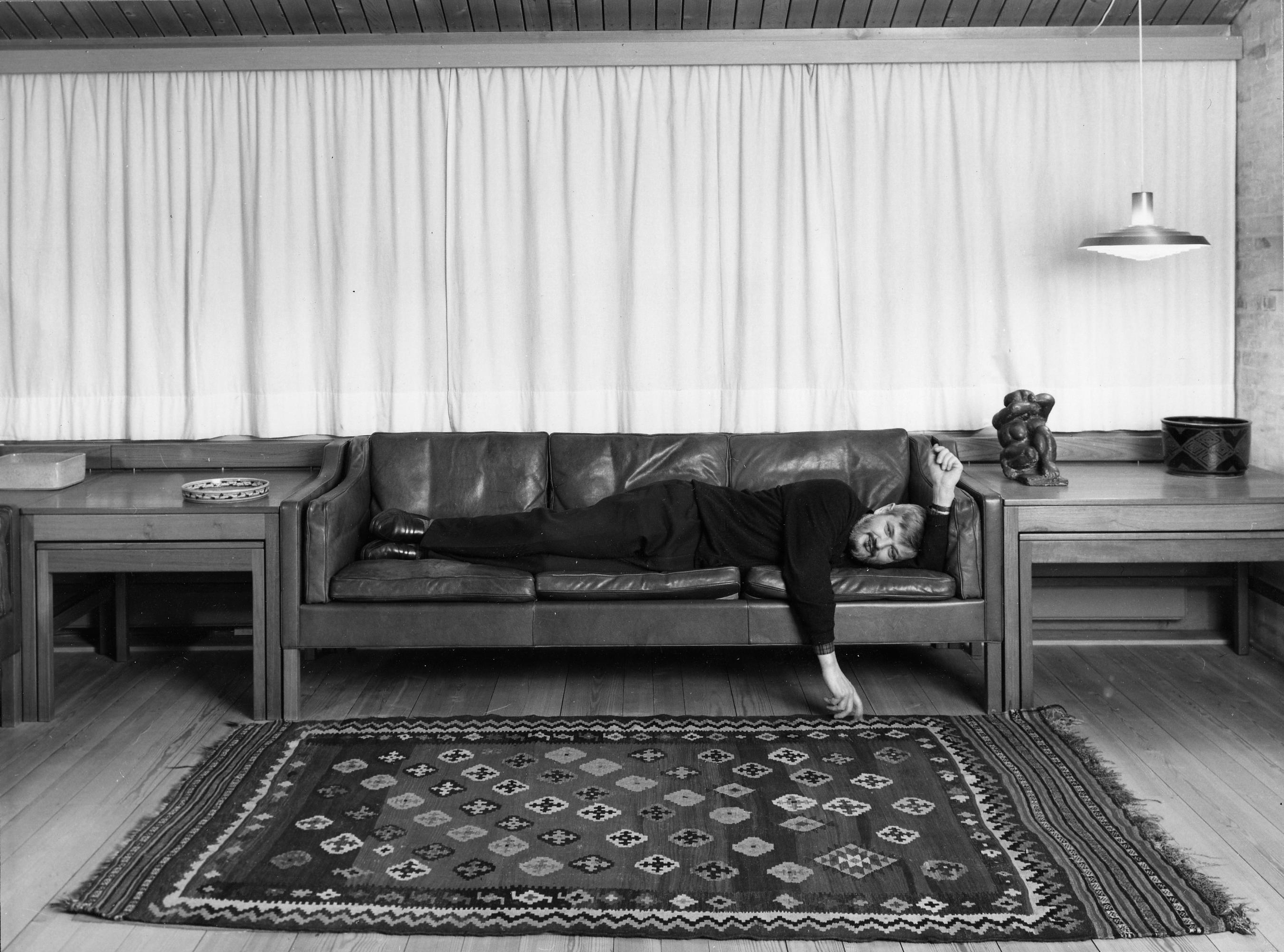 Børge Mogensen at home test-reclining on a prototype of his ‘Embassy Sofa’
