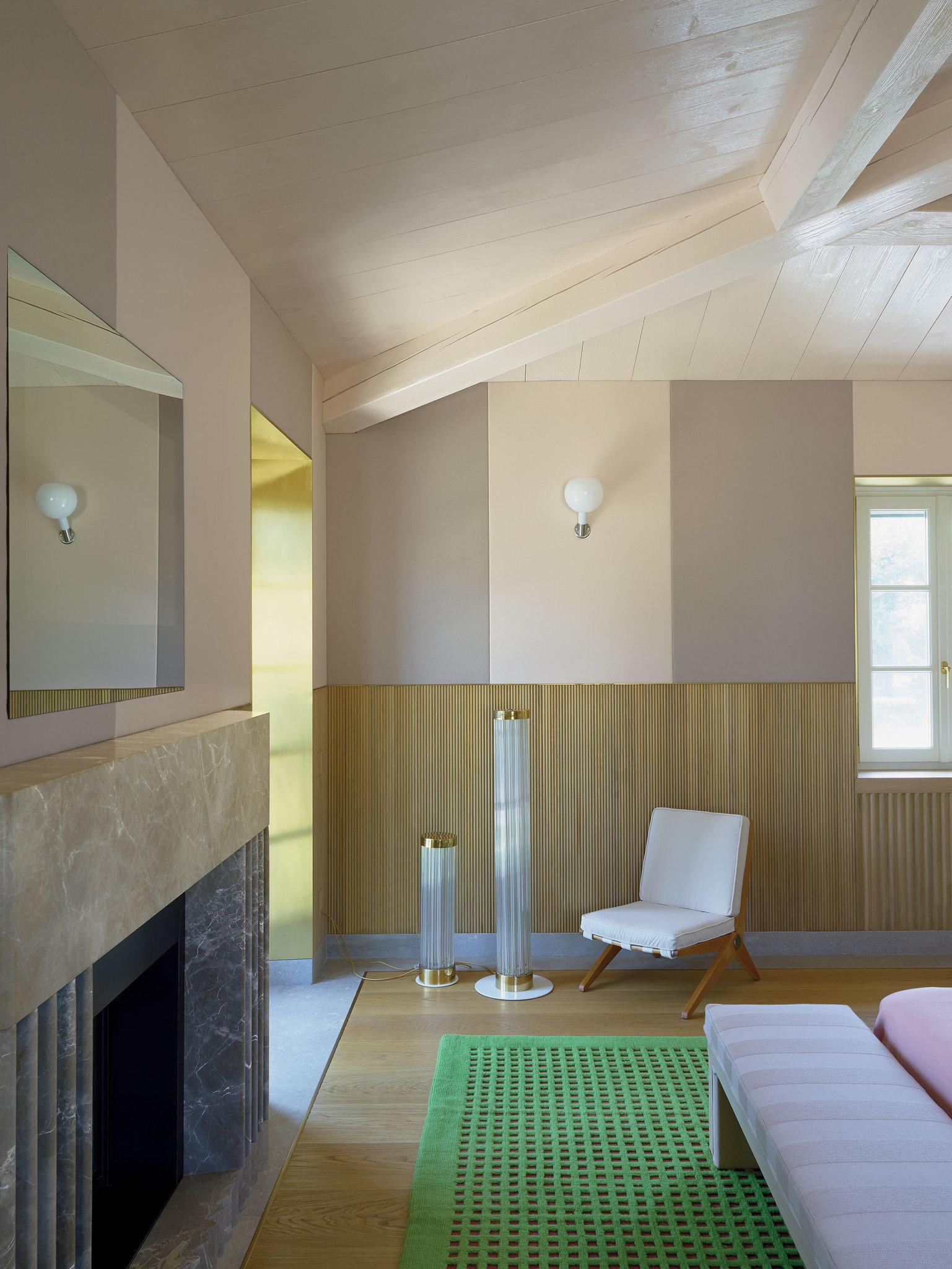 In the master bedroom, the emperador custom marble fireplace, the chairs designed by Pierre Jeanneret for Knoll in 1952, the Kvadrat fabrics, the carpet is by Cogolin and the lamps come from the Morentz gallery. Photo: Henry Bourne