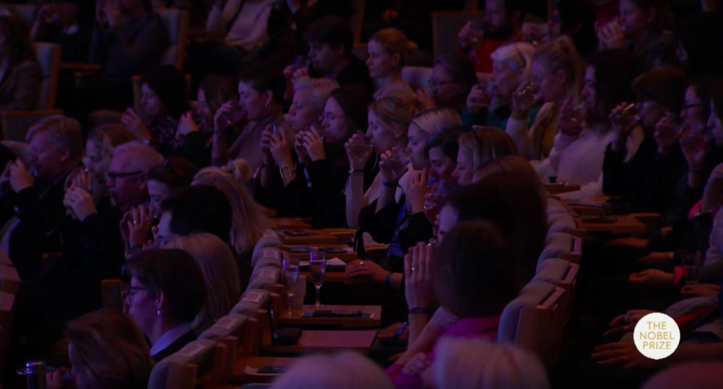Il pubblico durante l’esercizio proposto dall’artista alla Nobel Week