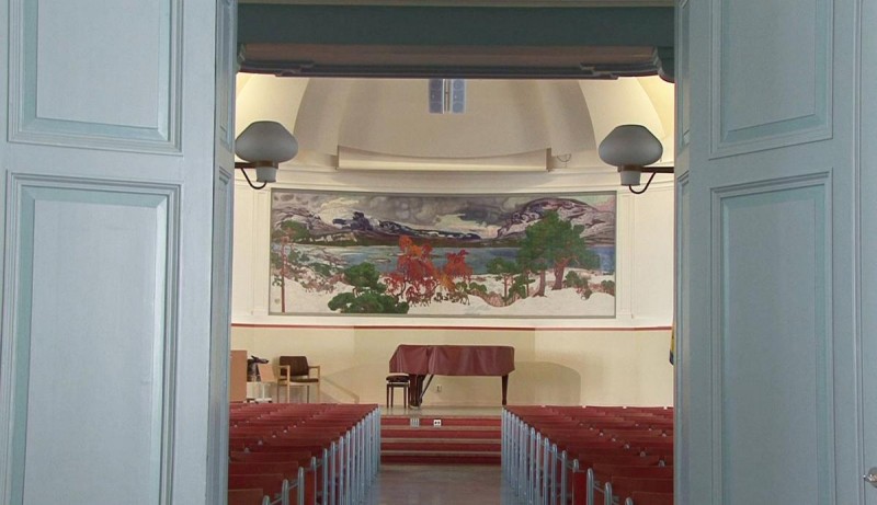 Fotografi från Vasaskolans aula med väggmålningen av Osslund. Foto via dokumentärfilmen "Helmer Osslund – från Paris till Abisko".